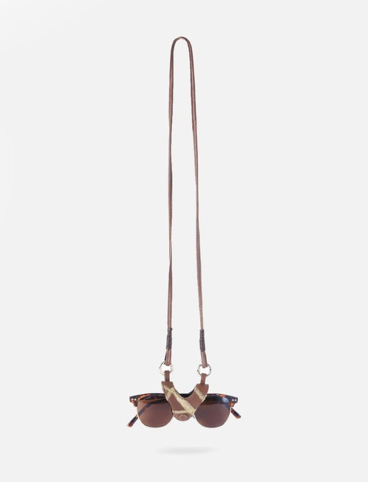 Close-up shot of a hand holding a protective full-grain leather sunglass case with a secure magnetic flap